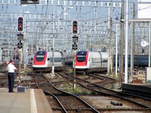 Two trains pulling into a station in Switzerland under the type of 'pulse' transfer system the California State Transportation Agency wants to emulate. Wikimedia Commons