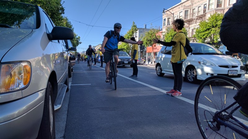 A bike commuter high-fives an advocate for protecting him on the southbound Valencia bike lane during a May protest. Streetsblog/Rudick