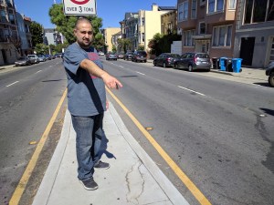 Peter Bagain, owner of a deli just north of the intersection, pointing at the dried blood still on the street. Photo: Streetsblog/Rudick