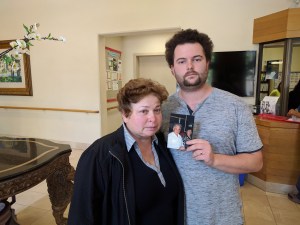 The victim's family, daughter Inessa Grinberg and grandson Roman, with a photo of David. Photo: Streetsblog/Rudick