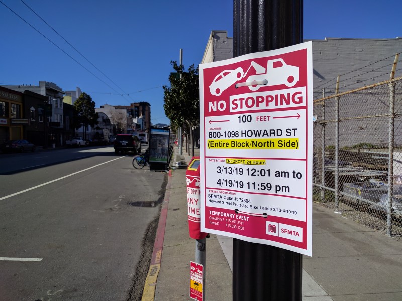 SFMTA's Rapid Response team has put up "no stopping" signs on Howard and bagged the parking meters. Note the black SUV driving half in the bike lane up ahead. Photos: Streetsblog/Rudick