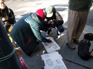 Protesters at a vigil held in May, painting "ghost feet" where  a man was run down by a bus in the Tenderloin. Photo: Streetsblog/Rudick