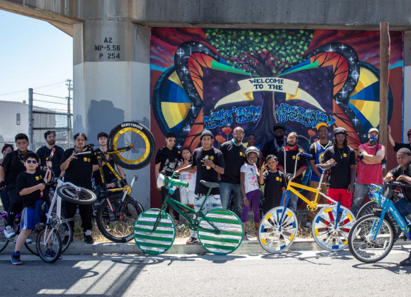 The Scraper Bike Team in front of a mural in Fruitvale. Scraper is one of many local groups helping guide new bike infrastructure in Oakland. Photo: OakDOT