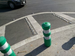A corner on a protected intersection in San Jose, with two radii. The outer one, made of reflective bumps, warns drivers that they're taking the turn too close.