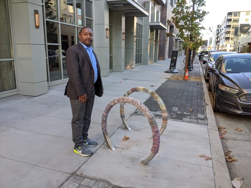 Kenya Wheeler, SFMTA planner and head of the Oakland BPAC, back at the spot where he was detained and threatened for taking pics of yarn-wrapped bike racks. Photo: Streetsblog/Rudick