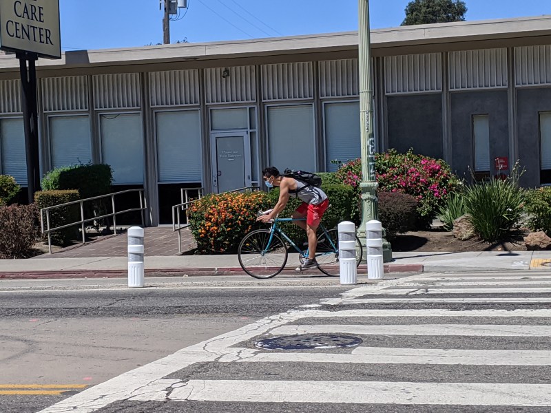 A cyclist protected by Oakland's newly installed bollards on Telegraph in July of last year. Photos Streetsblog/Rudick