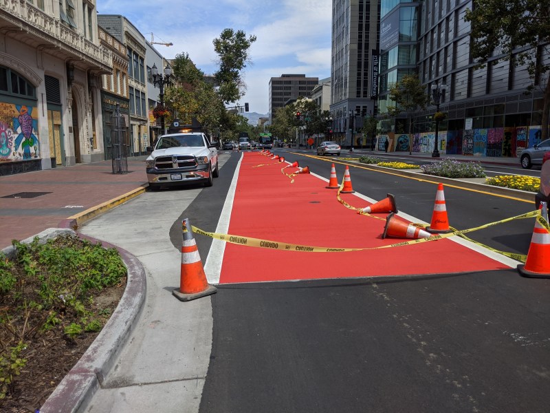 Oakland city crews are painting the streets red in downtown Oakland. Photo: Streetsblog/Rudick