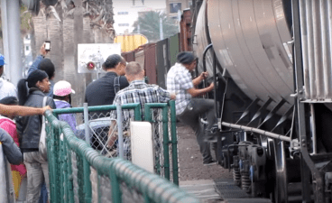 Screen capture from a video of Padre fans in San Diego climbing over and under a freight train near Petco Park. Could this be the scene in Jack London Square some day? Image:  Tcostello105's video on YouTube