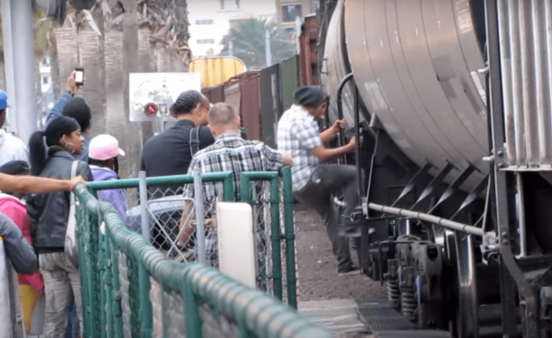 Screen capture from a video of Padre fans in San Diego climbing over and under a freight train near Petco Park. Could this be the scene in Jack London Square some day? Image: Tcostello105's video on YouTube