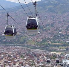 Medellín Metrocable cars. Researchers found a correlation between infrastructure investments in the station neighborhoods and lower homicide rates and increased societal trust. Photo: Camilo Sanchez via Wikipedia