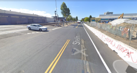 A sidewalk-level protected bike lane will eventually be built to the right of that barricade. Photo: Google Streetview