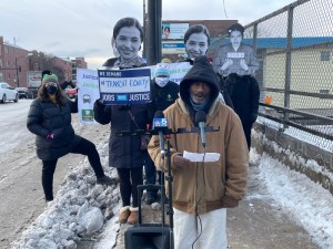 Alfred White, a temp worker and volunteer with Warehouse Workers Together, speaks at the event. Behind him attendees hold Rosa Parks cutouts. Photo: Cameron Bolton