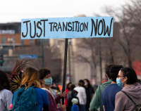 A woman holds a Just Transition Now sign at a rally in Minneapolis, Minnesota. Image: Lorie Shaull, CC