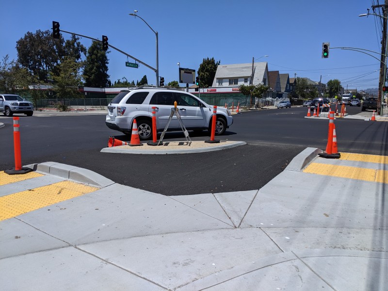 A motorist taking the corner at West and MacArthur slowly and carefully, thanks to the new protected intersection. Nice, but Oakland needs to work on corners on all its streets. Photos: Streetsblog/Rudick